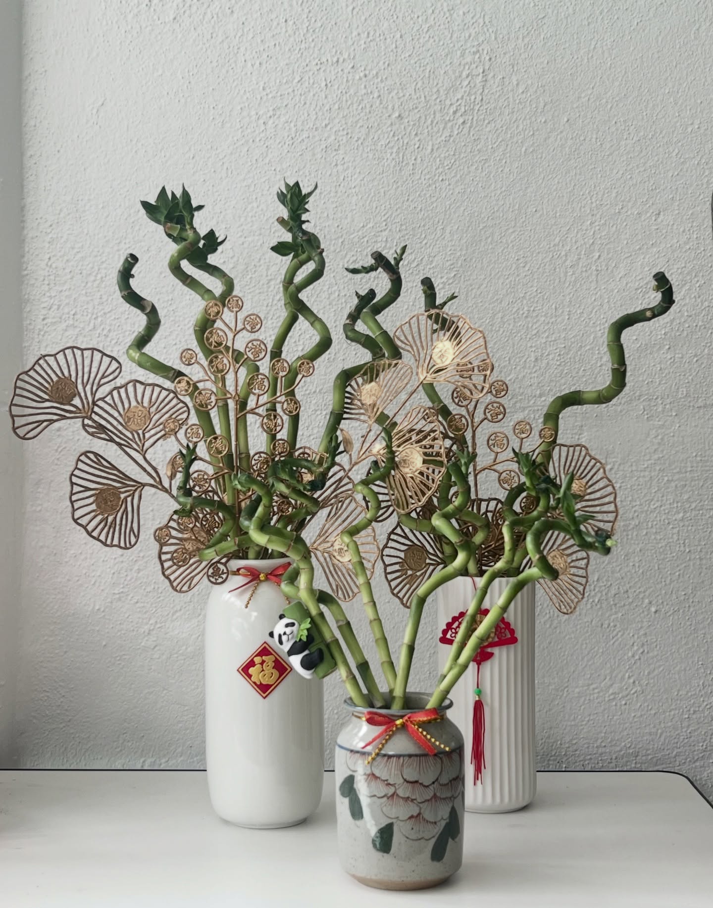Lucky bamboo in ceramic vases with gold fortune fans